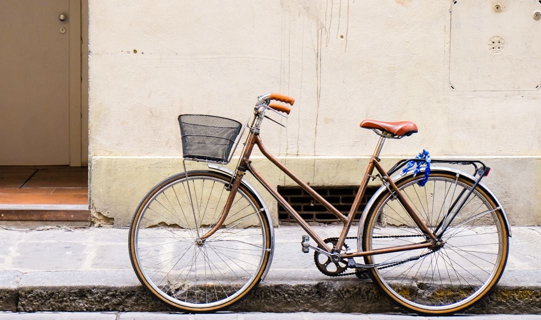 Una bicicleta apoyada en la acera.