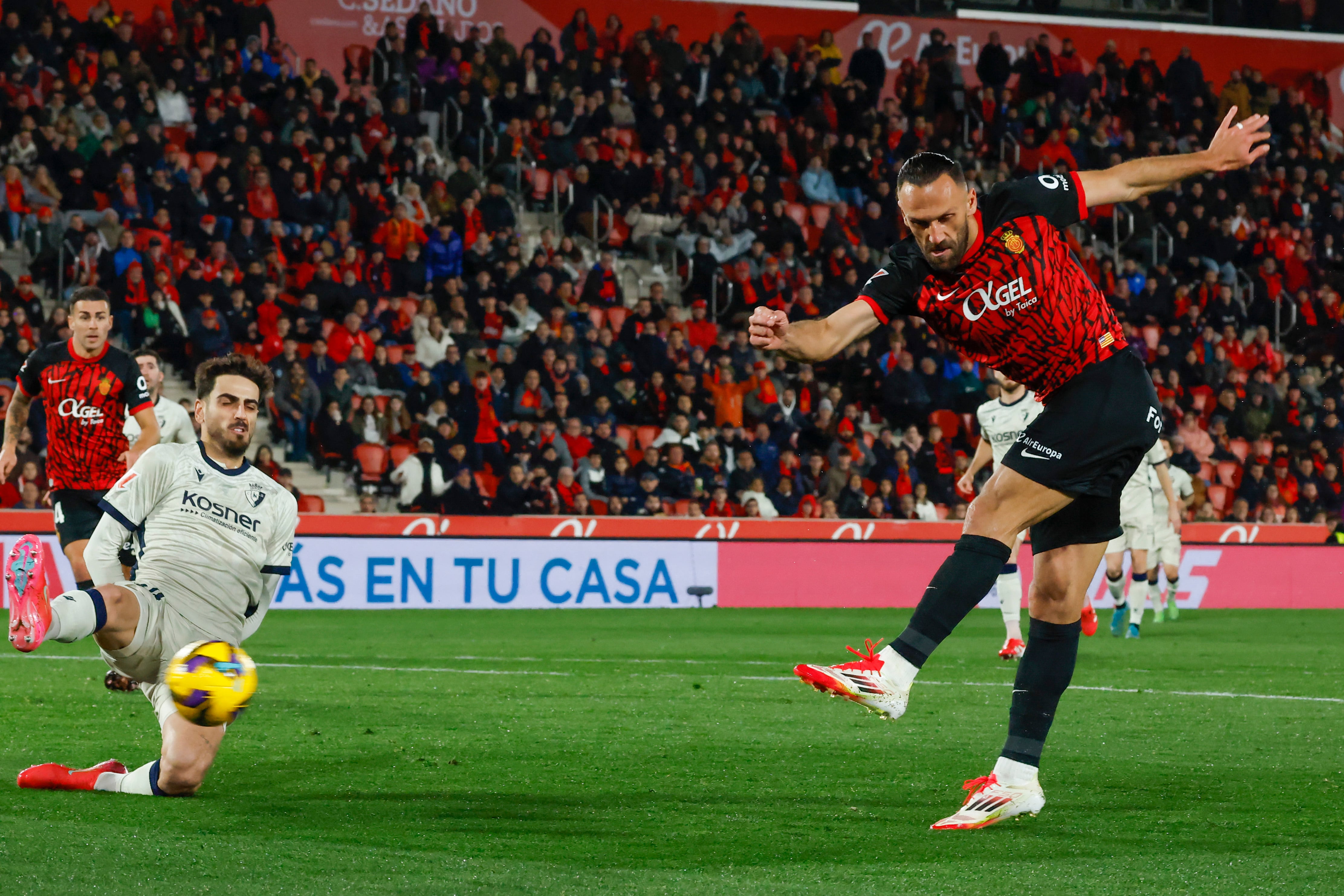 PALMA DE MALLORCA, 10/02/2025.- El delantero kosovar del RCD Mallorca, Vedat Muriqi (d), remata ante el centrocampista de Osasuna, Alejandro Catena, durante el encuentro correspondiente a la jornada 23 de Laliga EA Sports que disputan hoy lunes RCD Mallorca y Osasuna en el estadio de Son Moix, en la capital balear. EFE/CATI CLADERA.
