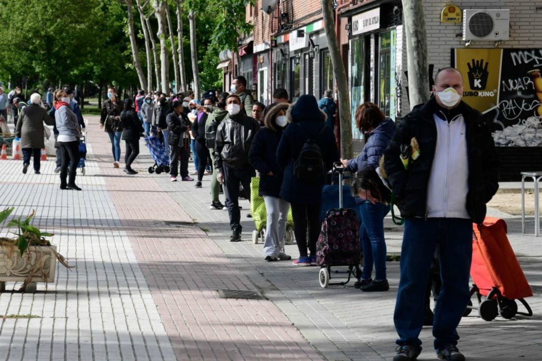 Colas de personas a la espera de recibir productos en el banco de alimentos de Aluche (Madrid).