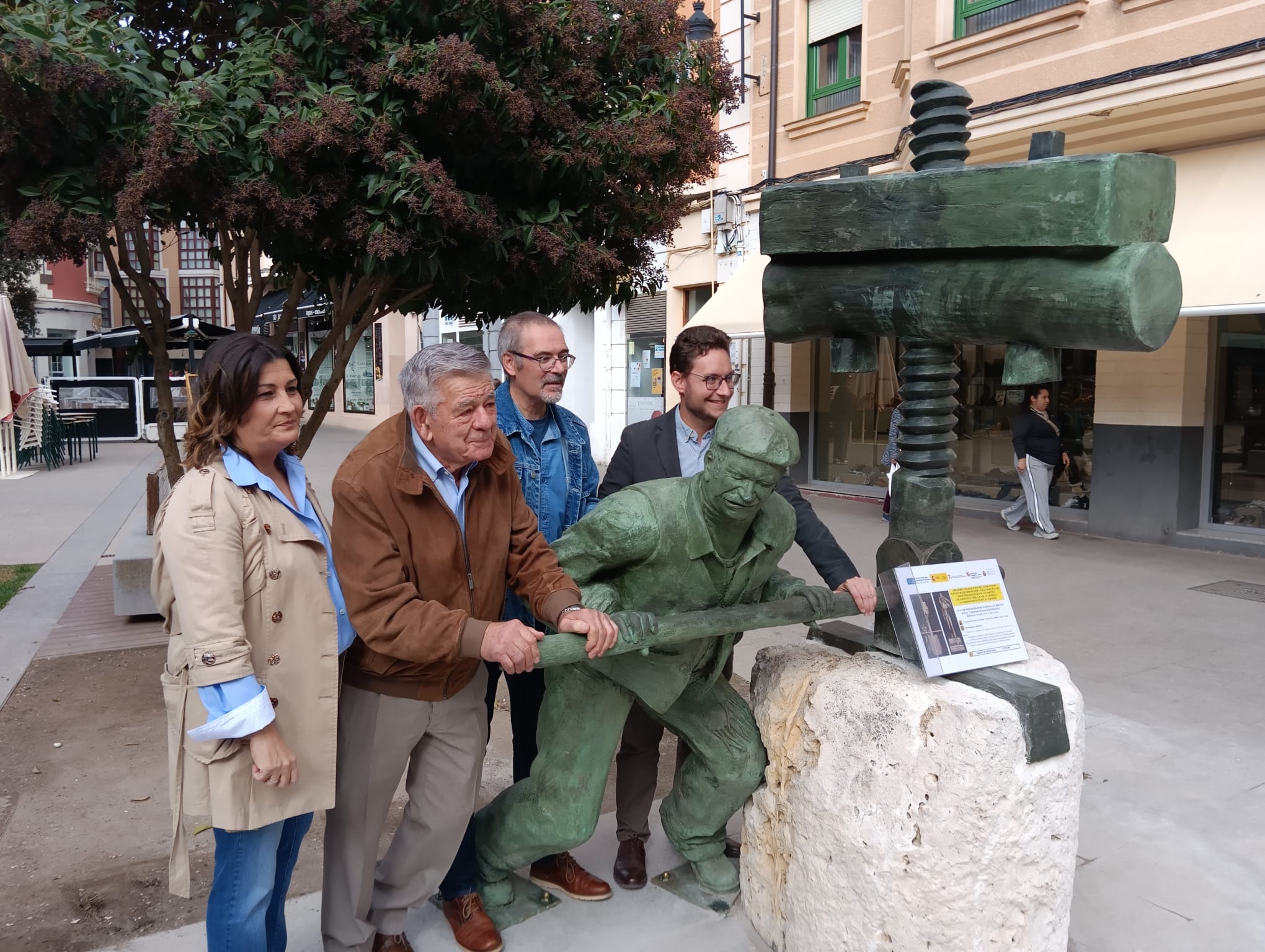 Un aparcero de carne y hueso posa con la concejala de Turismo, el autor y el alcalde con la figura ubicada en la Plaza de la Constitución