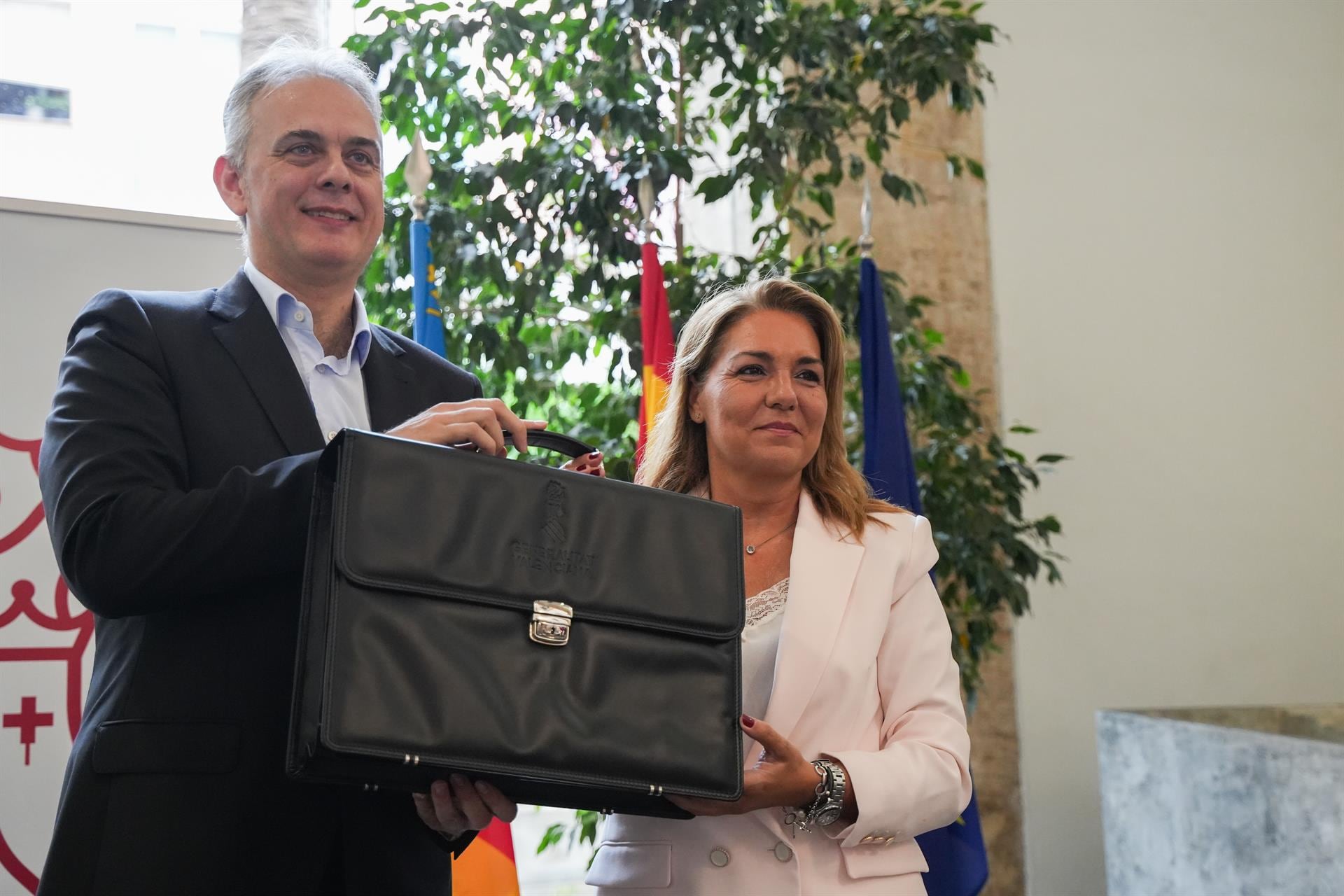 Susana Camarero recoge la cartera de la mano del exvicepresident Héctor Illueca