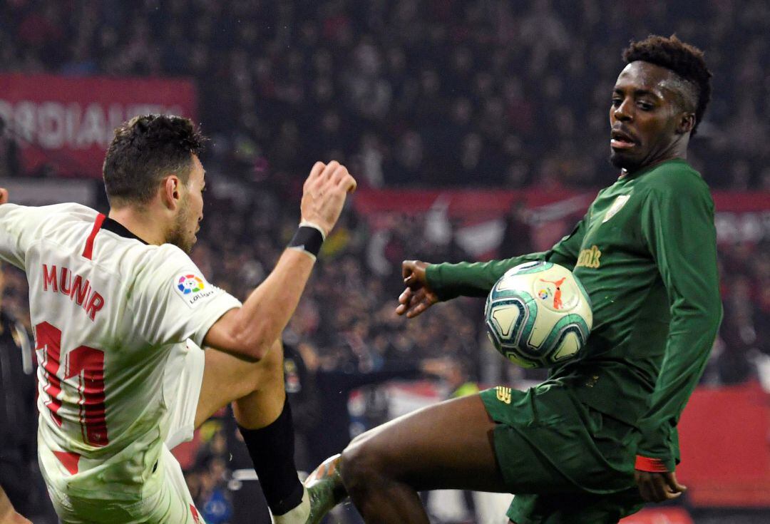 El delantero Munir El Haddadi (i), del Sevilla FC, lucha con Iñaki Williams, del Athletic Club de Bilbao, durante el partido de la 19ª jornada de LaLiga jugado este viernes en el estadio Ramón Sánchez-Pizjuán de Sevilla