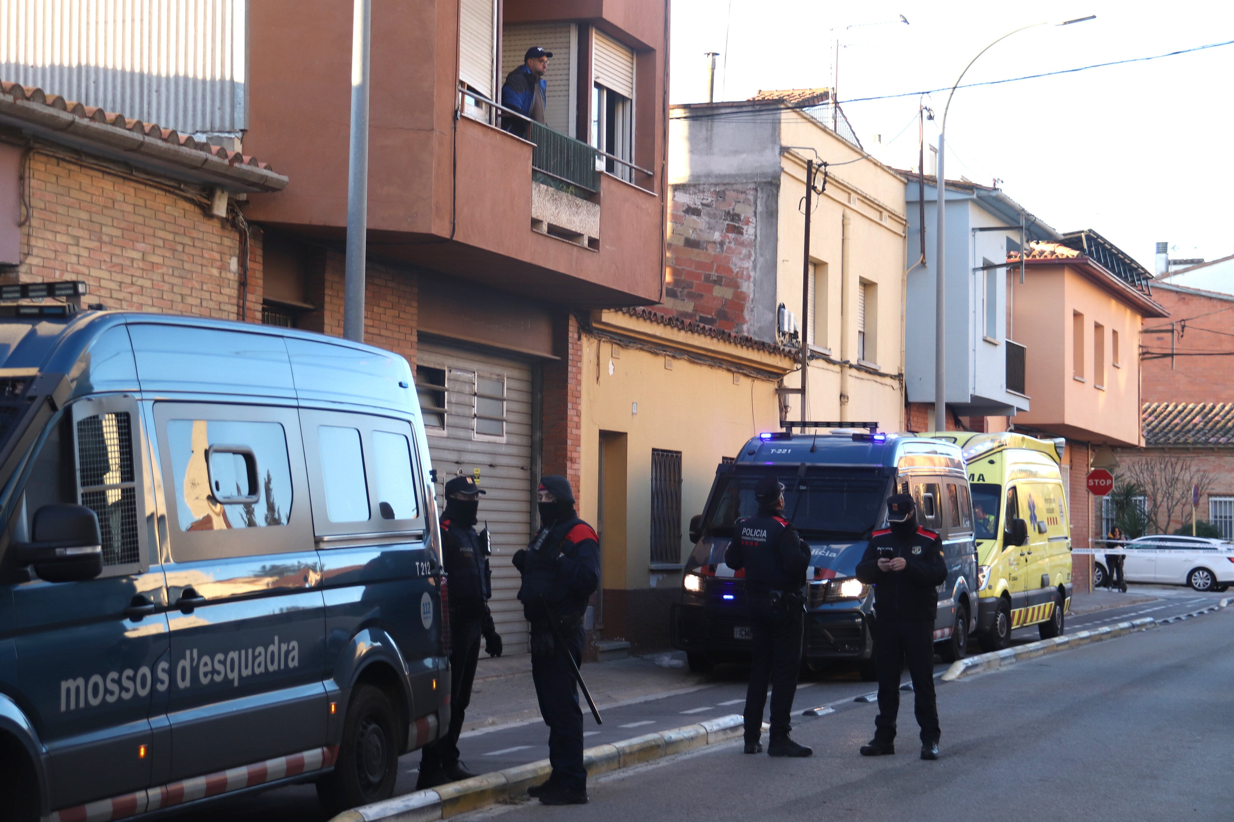 Un home mira pel balcó minuts abans de ser desnonat del pis mentre els Mossos d&#039;Esquadra vigilen al carrer