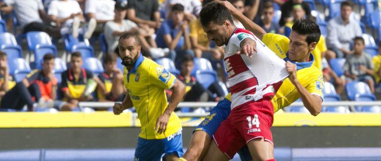 Vicente Gómez, de Las Palmas, lucha por el balón con Luis Martins del Granada FC.