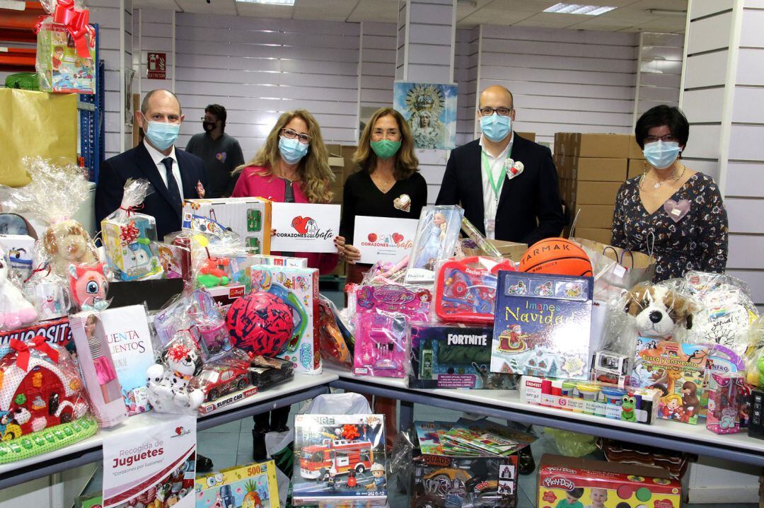 La consiliaria de Asistencia Social de la Hermandad de la Macarena, María Luisa Gayán, en el centro de la imagen, recibe los juguetes recogidos por la asociación &#039;Corazones con bata&#039;