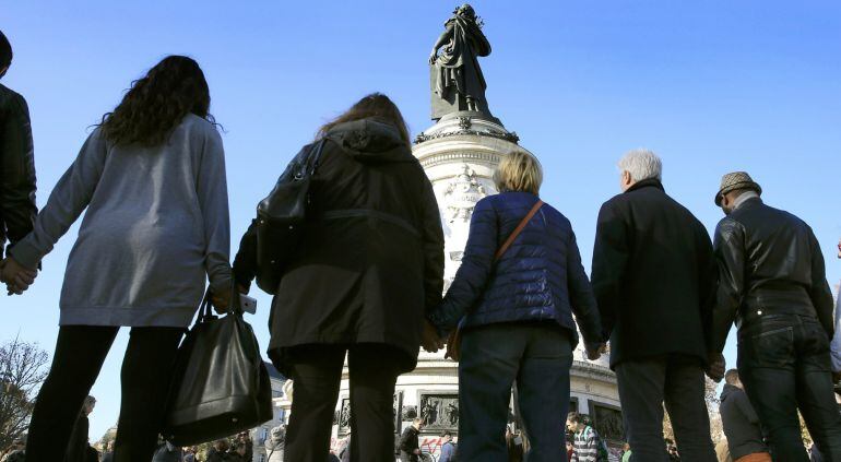 Gente agarra sus manos en señal de solidaridad por las víctimas de Francia. 