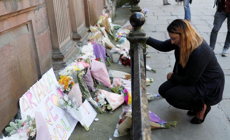 Una mujer deja flores en el lugar del atentado. 