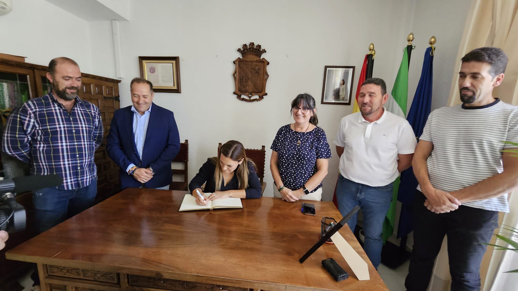 Momento de la firma de la delegada, María José Lara, en el Libro de Honor del Ayuntamiento de Jódar, en presencia de los concejales del equipo de gobierno