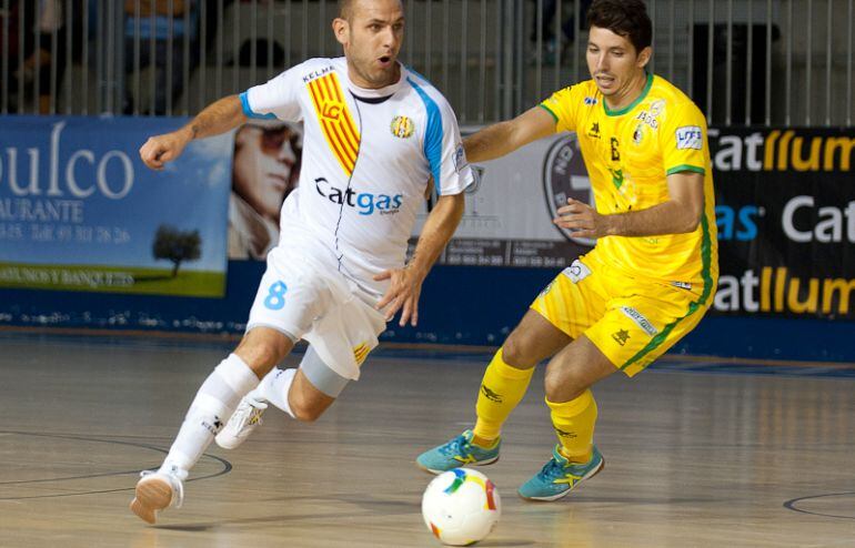 El amarillo Murga pugna por el balón con un jugador catalán.