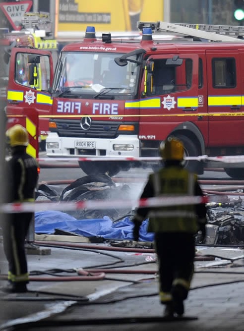 Bomberos y servicios de emergencia trabajan en el lugar donde se ha estrellado un helicóptero en el centro de Lonres (Reino Unido)