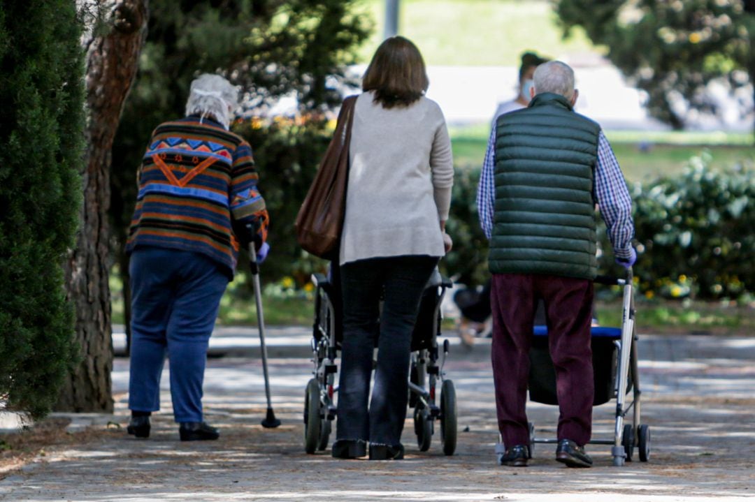 Dos ancianos y una mujer en el primer día en que los españoles pueden salir de casa a pasear y hacer ejercicio al aire libre