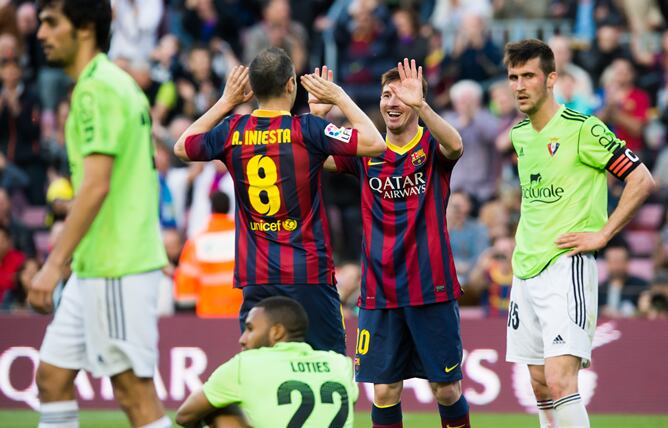 Iniesta y Messi celebran uno de los goles del triplete del argentino