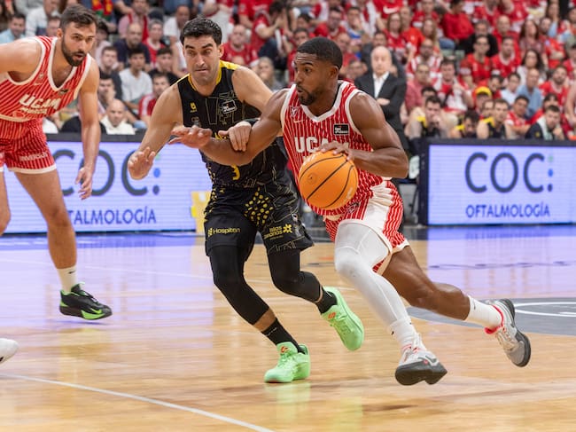 MURCIA, 25/04/2026.- El base estadounidense de UCAM Murcia David DeJulius (d), controla en balón ante la presión del escolta de La Laguna Tenerife Jaime Fernández (c), durante el partido de la vigésima octava jornada de la liga Endesa que están disputando este sábado en el Palacio de los Deportes de Murcia. EFE/Marcial Guillén
