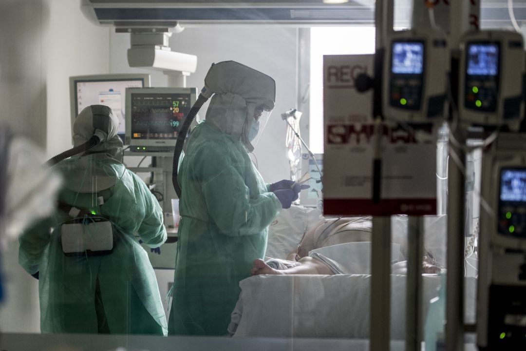 Personal sanitario atendiendo a un paciente de COVID-19 en la UCI. 