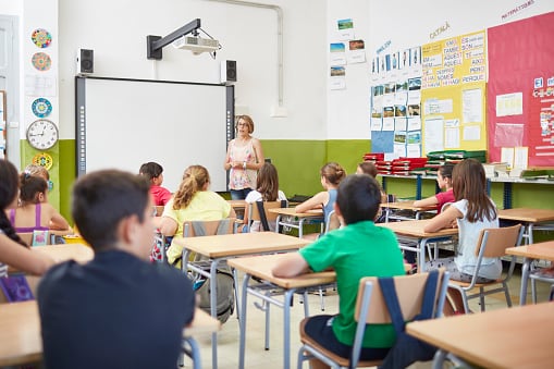 Una profesora enseña a sus alumnos en el aula