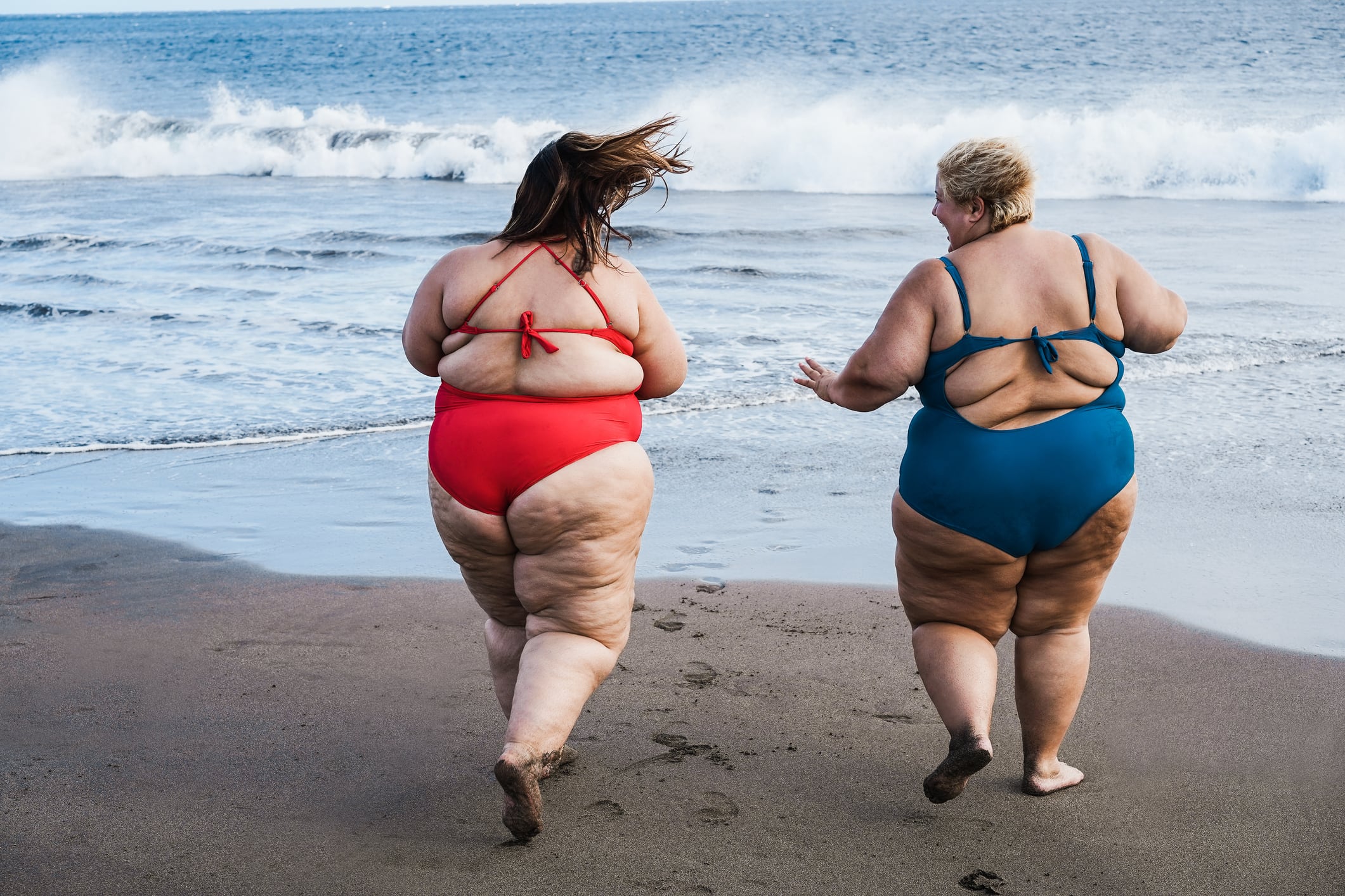 Dos mujeres obesas, entrando en la playa.