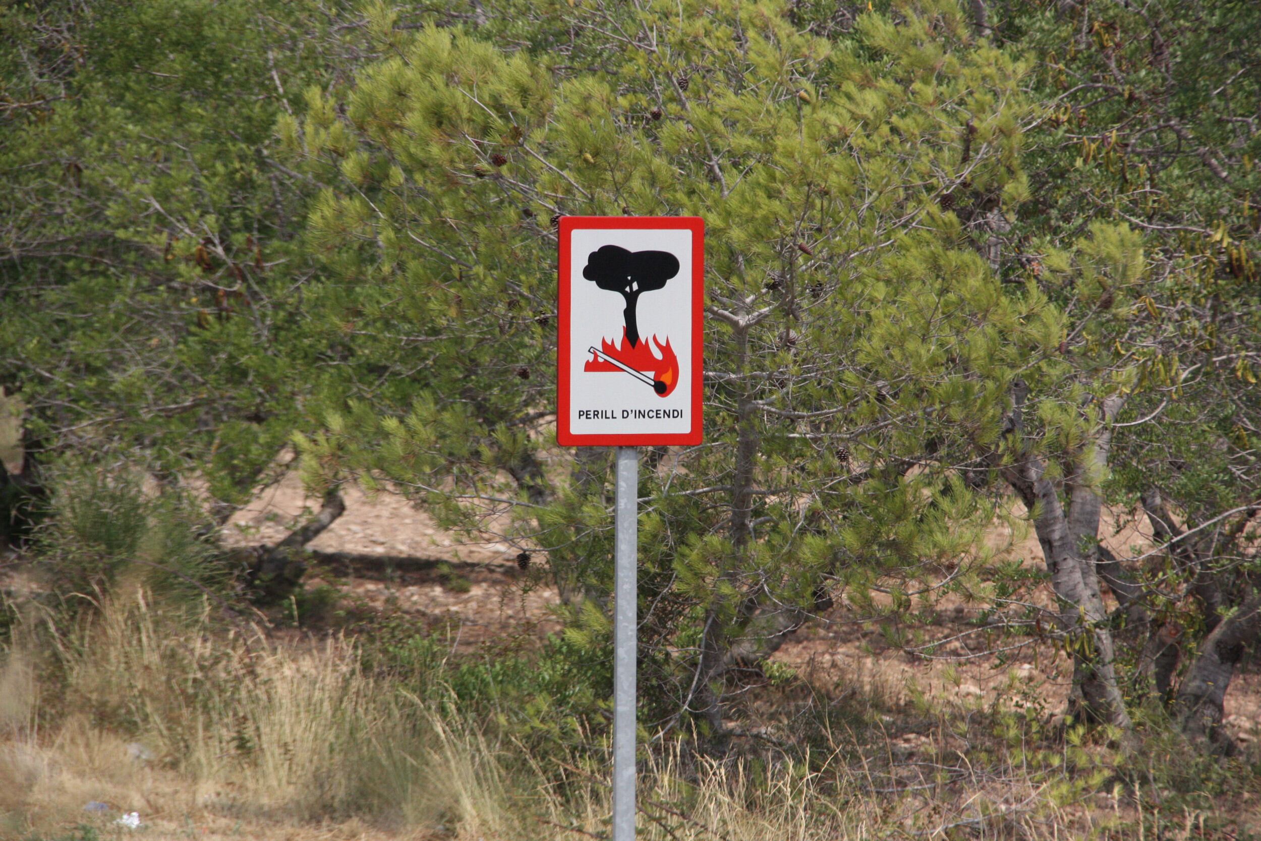 Pla detall del senyal de perill per incendi en una carretera pròxima al foc dels Pallaresos del 22 de juliol de 2016. Horitzontal.