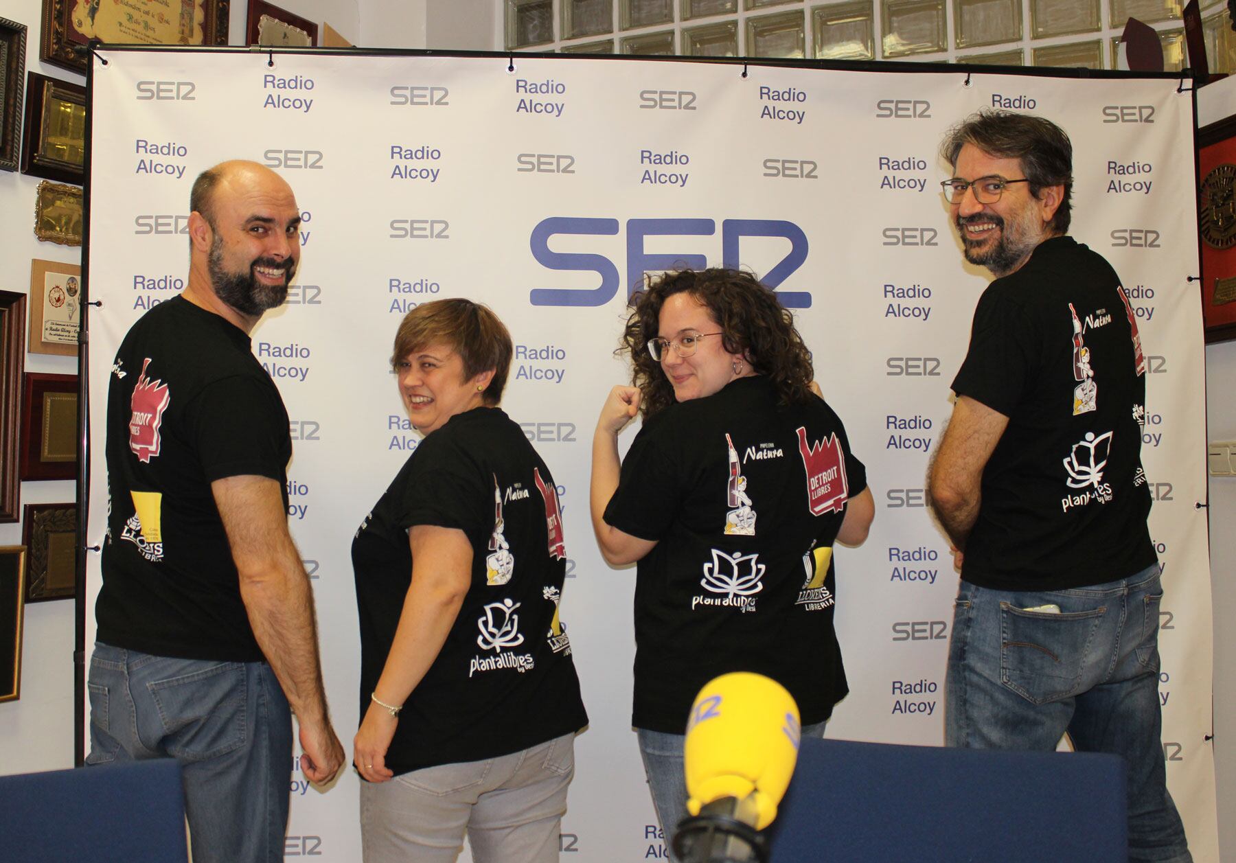 José Ernesto Nadal, Eva Girón, Desiré Doménech i Pau Grau, en l'estudi central de Ràdio Alcoi mostrant les samarretes commemoratives