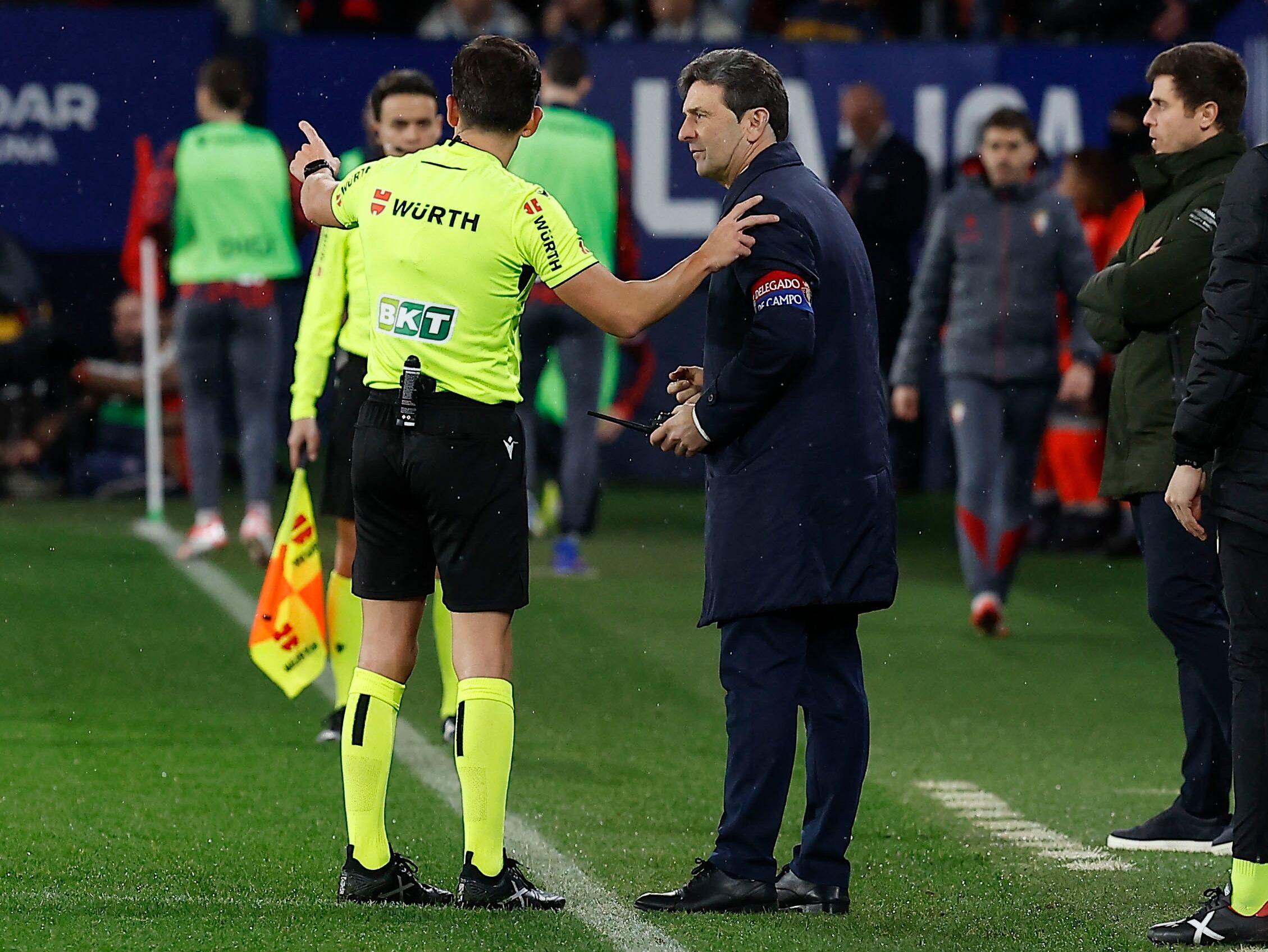 El árbitro Quintero González avisa al delegado de campo de Osasuna que se ha recogido un mechero lanzado desde la grada