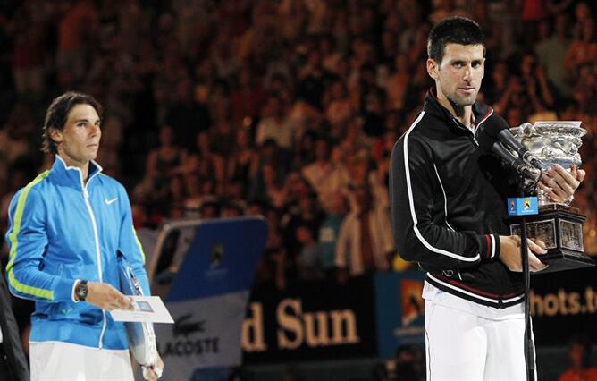 El tenista español Rafa Nadal y el serbio Novak Djokovic sostienen sus respectivos trofeos después de la final del Abierto de Australia que disputaron Melbourne. Djokovic se impuso a Nadal por 6-7, 6-4, 7-6, 6-7 y 6-4 en la final más larga en la historia 