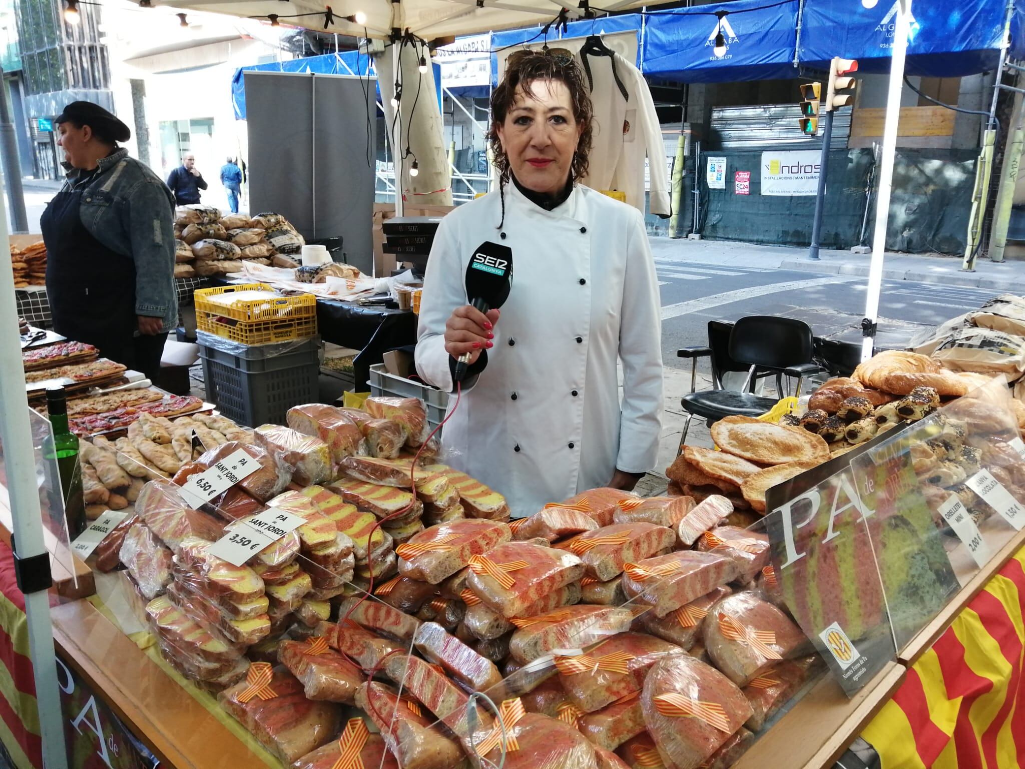 La presidenta del gremi de forners de Lleida darrere el taulell de la parada que el gremi de forners ha muntat a Rambla Ferran avui, Sant Jordi.