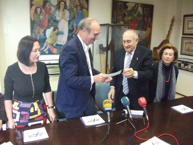 El presidente de la Venida de la Virgen entrega el cheque al responsable de Cáritas