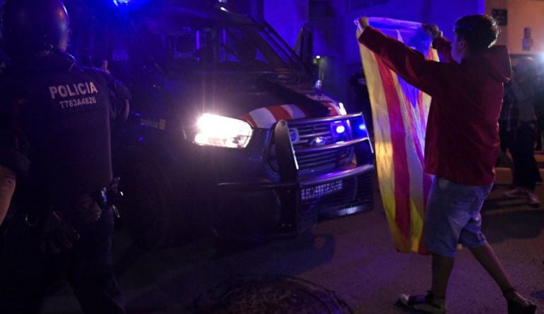 Un joven sostiene una estelada frente a un furgón policial el 20-S