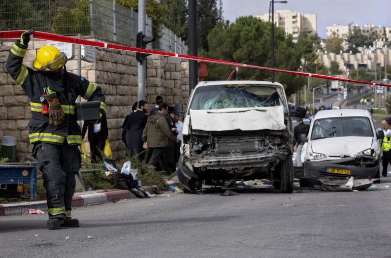 An Israeli fire fighter walks at the scene of an attack in Jerusalem, Wednesday, Nov. 5, 2014. A Palestinian man rammed his car into a crowded train platform in east Jerusalem on Wednesday and then attacked people with an iron bar, killing one person and 