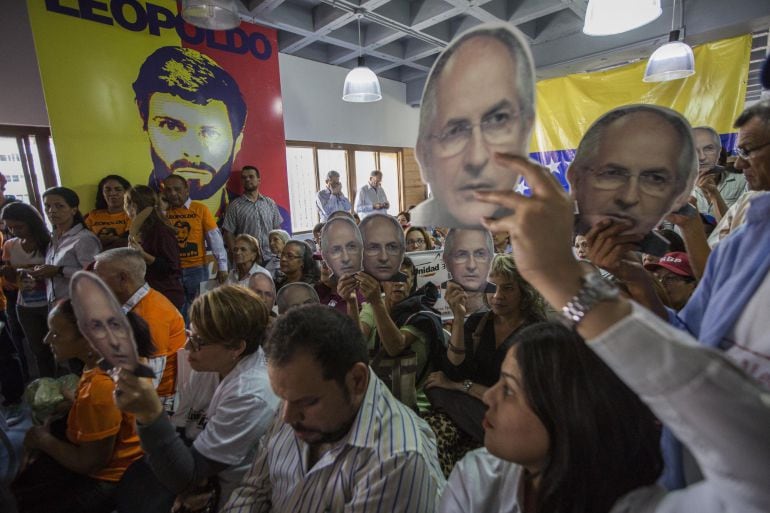 Un grupo de personas con afiches alusivos a leopoldo López y Antonio Ledezma asisten a una rueda de prensa de los partidos políticos Voluntad Popular y Alianza Bravo Pueblo 