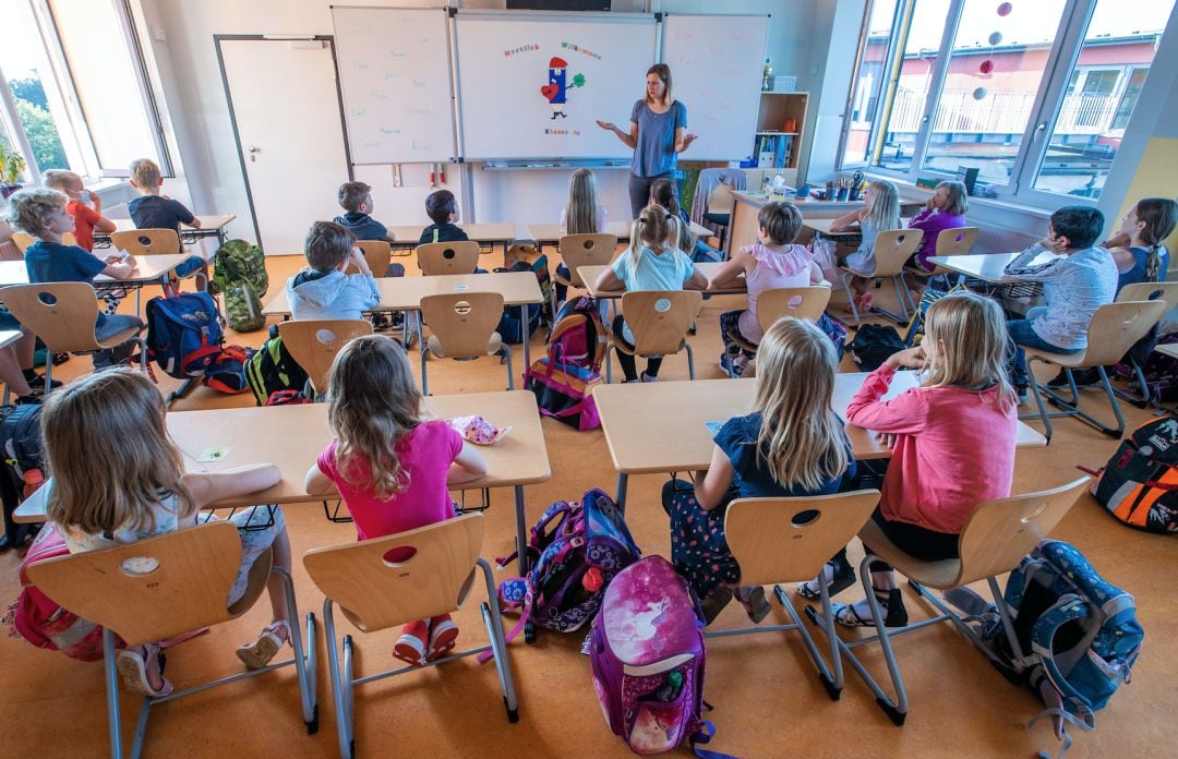 Una profesora da la bienvenida a alumnos de tercer curso en su aula de la escuela primaria de Lankow al primer día escolar después de las vacaciones de verano en Mecklemburgo-Pomerania Occidental (Alemania)