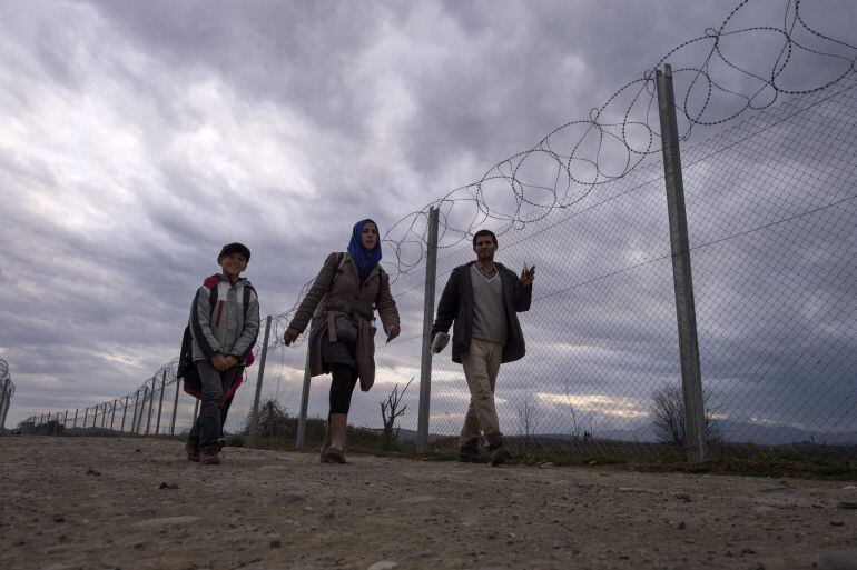 Refugiados se dirigen al centro de registro tras cruzar la frontera entre Grecia y Macedonia,