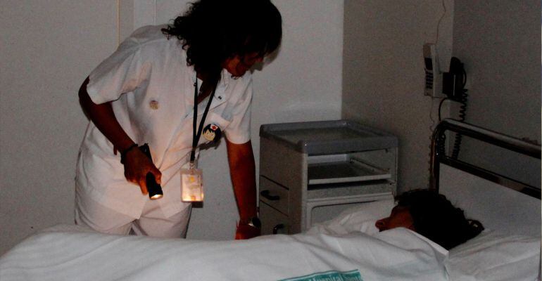 Una infermera utilitzant un lot per entrar a veure una pacient a la seva habitació a la nit