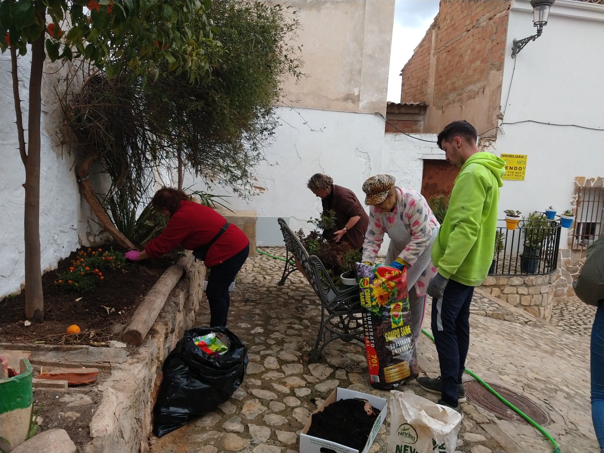 Vecinos de la zona del casco antiguo de Peal de Becerro plantan las flores cedidas por el Ayuntamiento.