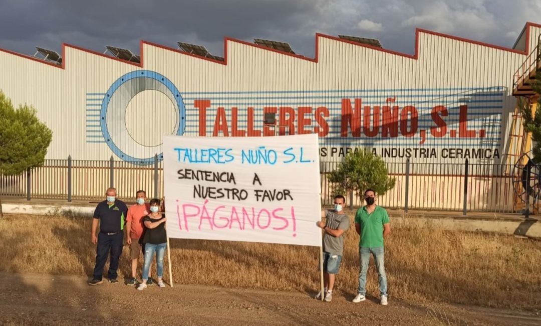 Los cinco trabajadores pendientes de cobrar sus salarios e indemnizaciones se manifiestan frente a las puertas de su antigua empresa 