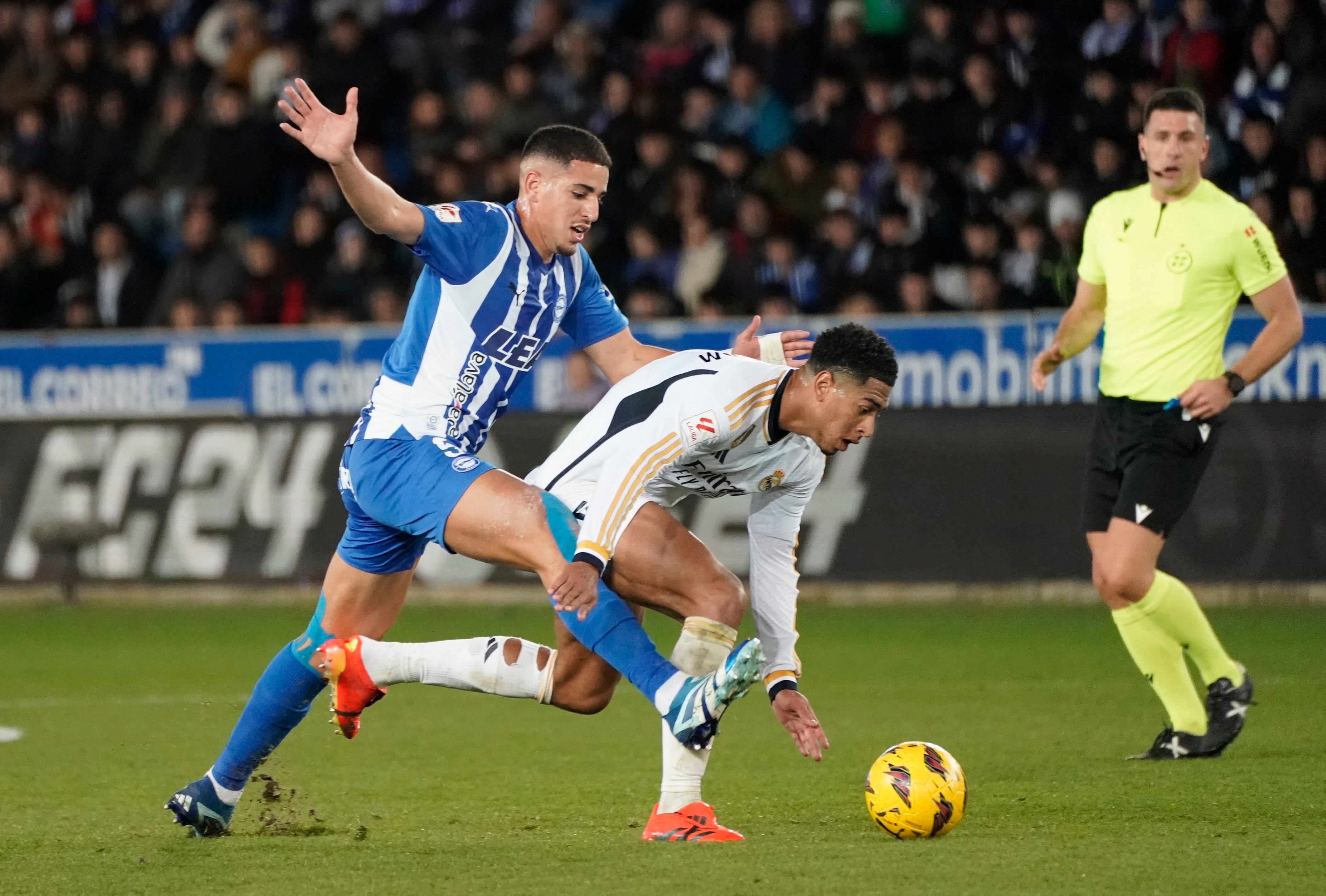 Abdelkabir Abqar lucha con el centrocampista británico del Real Madrid Jude Bellingham durante el encuentro de la jornada 18 de LaLiga entre el Deportivo Alavés y el Real Madrid en el Estadio de Mendizorroza, en Vitoria. EFE/L. Rico