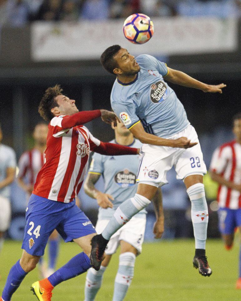 El defensa argentino del Celta de Vigo Gustavo Cabral (d) despeja de cabeza junto al croata Duje Cop, del Sporting de Gijón, durante el partido de la quinta jornada de la Liga de Primera División que se jugó en el estadio Balaídos, en Vigo.
