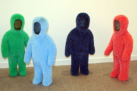 Imagen de pequeñas estatuillas con forma de teletubbie recubiertas de escamas de plástico de colores