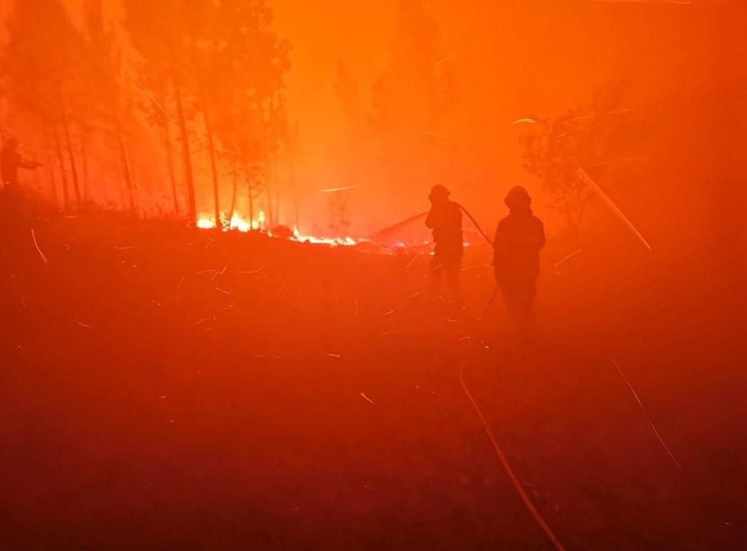 Dos bomberos luchan contra las llamas en Portugal. 