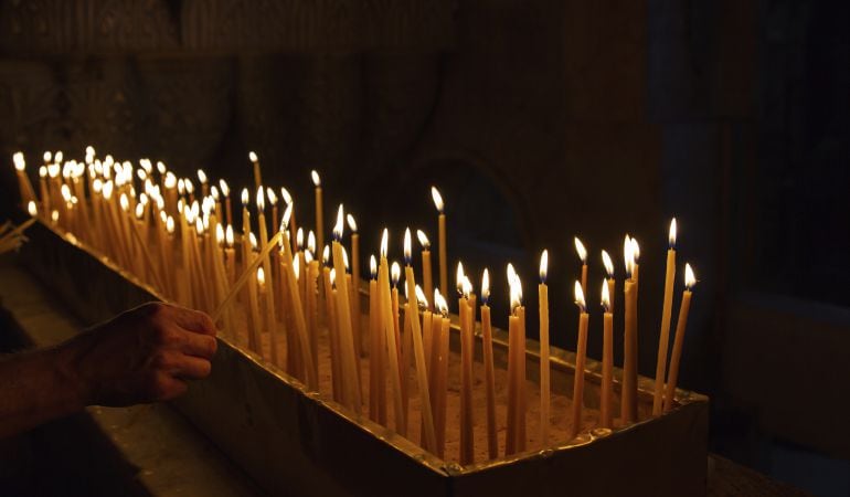 Imagen de un hombre encendiendo una vela.