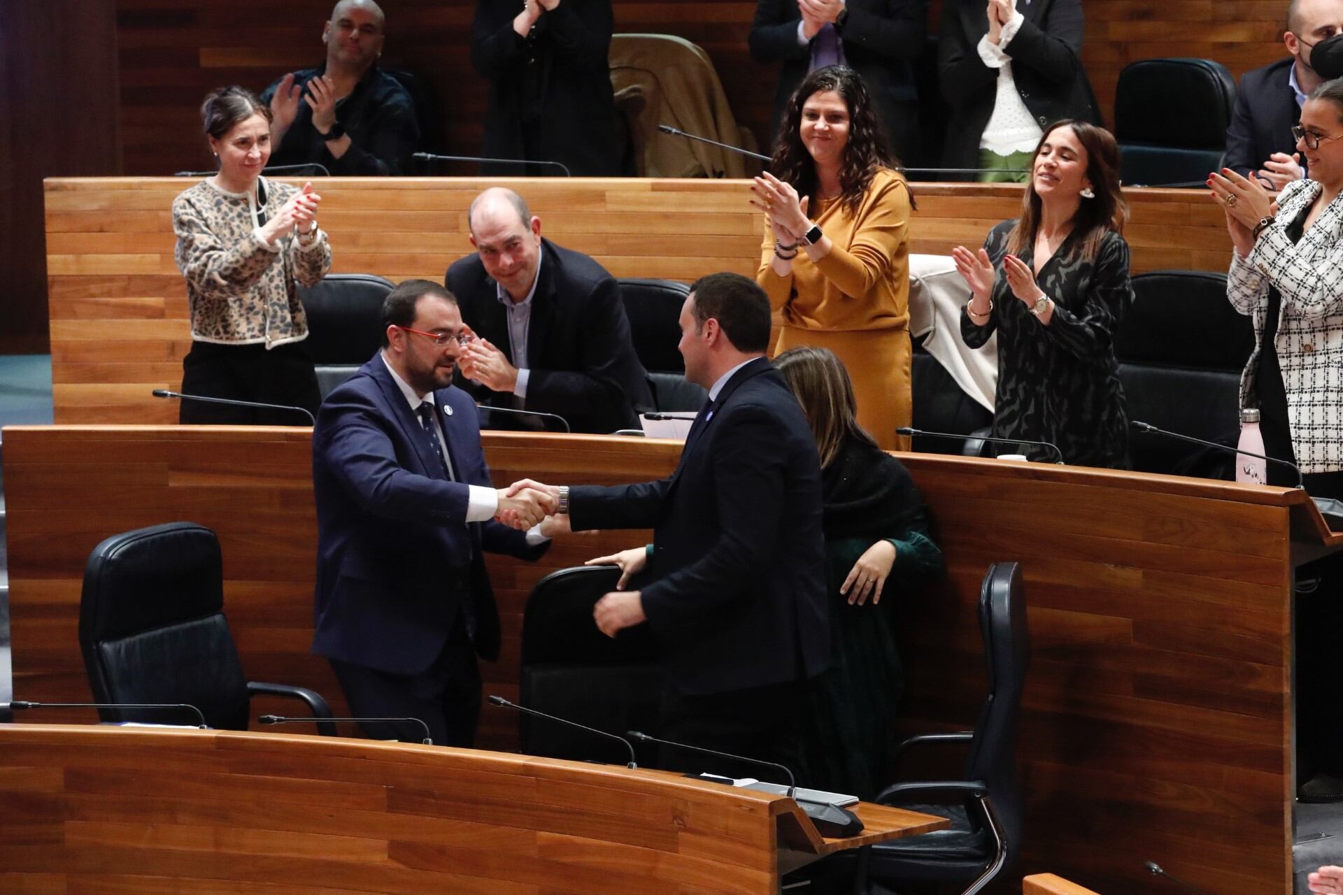 Adrián Barbón estrecha la mano del consejero de Hacienda mientras la bancada socialista celebra la aprobación de las cuentas para 2024.