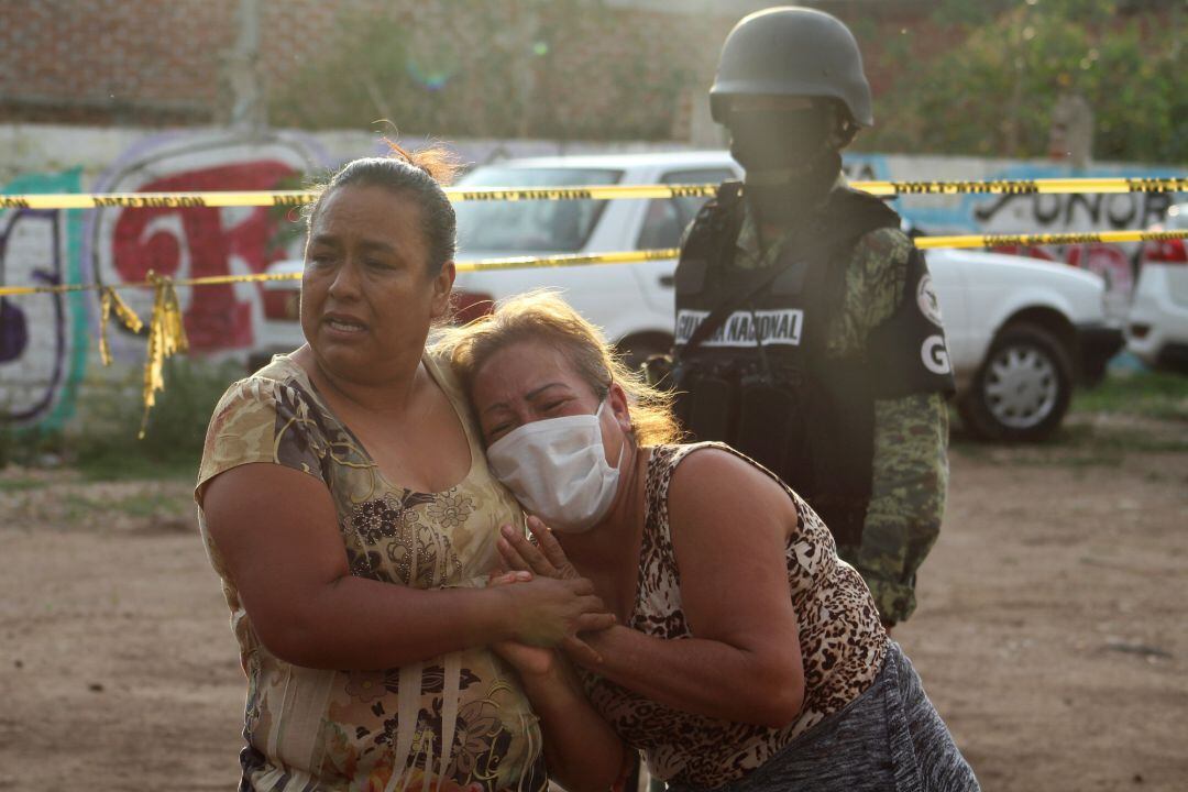 Dos mujeres lloran a la puerta del centro psiquiátrico donde han asesinado a 27 personas