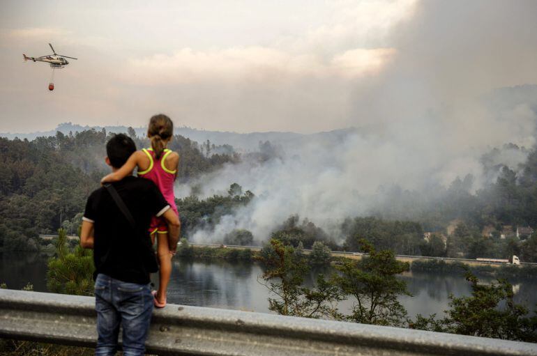 GRA269. Pereiro de Aguiar (Ourense).- Un helicoptero realiza trabajos de extinción sobre las llamas del incendio declarado desde ayer, en el termino municipal orensano de Pereiro de Aguiar. EFE/Brais Lorenzo.