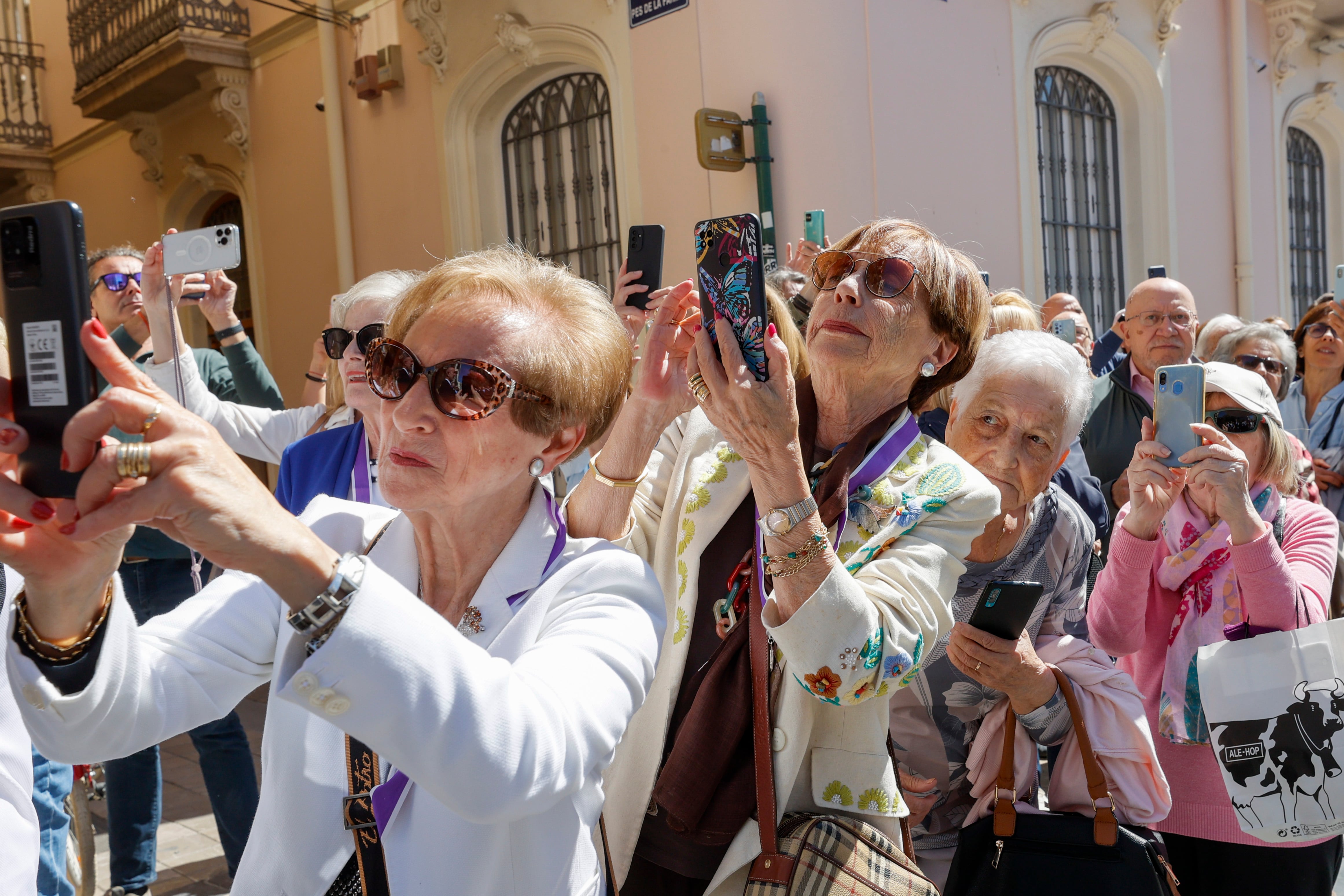 GRAFCVA3383. VALENCIA, 13/05/2023.-Varias personas con sus teléfonos móviles al paso de la procesión que celebra el centenario de la coronación de patrona de Valencia, , la Virgen de los Desamparados y que evoca a la que tuvo lugar hace un siglo.EFE/ Juan Carlos Cárdenas
