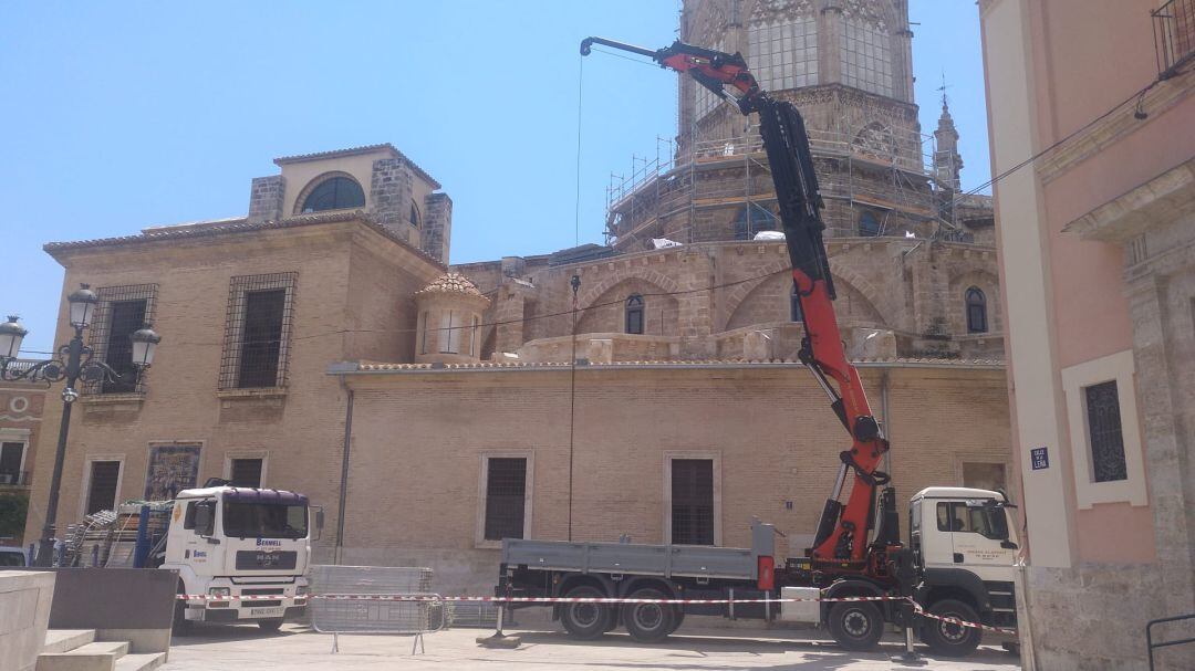 Una grúa instala los andamios en la Catedral de València.