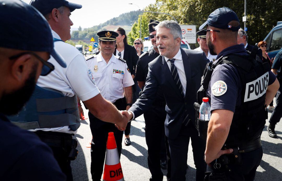 El ministro del Interior en funciones, Fernando Grande-Marlaska (c), saluda a dos policías franceses tras visitar el despiegue de la Policía Nacional en Biriatou (Francia), tras presidir la constitución del Centro de Coordinación Operativo (CECOR), entablecido en San Sebastián con motivo de la celebración de la cumbre del G7 en Biarritz (Francia). 