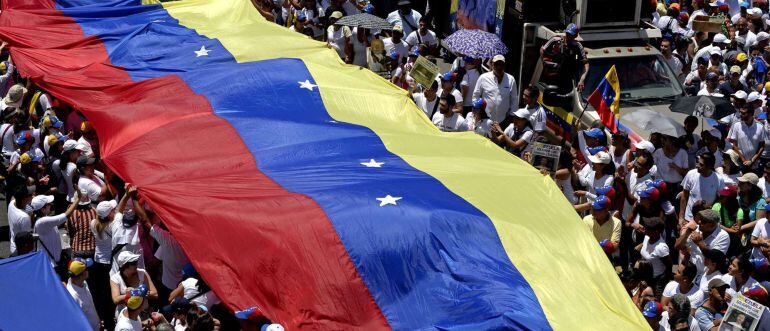 Opponents of Venezuelan President Nicolas Maduro carry a national flag during a peaceful demonstration against his government, in Caracas, on May 30, 2015. The protesters are also demanding the release of political prisoners, including that of opposition 