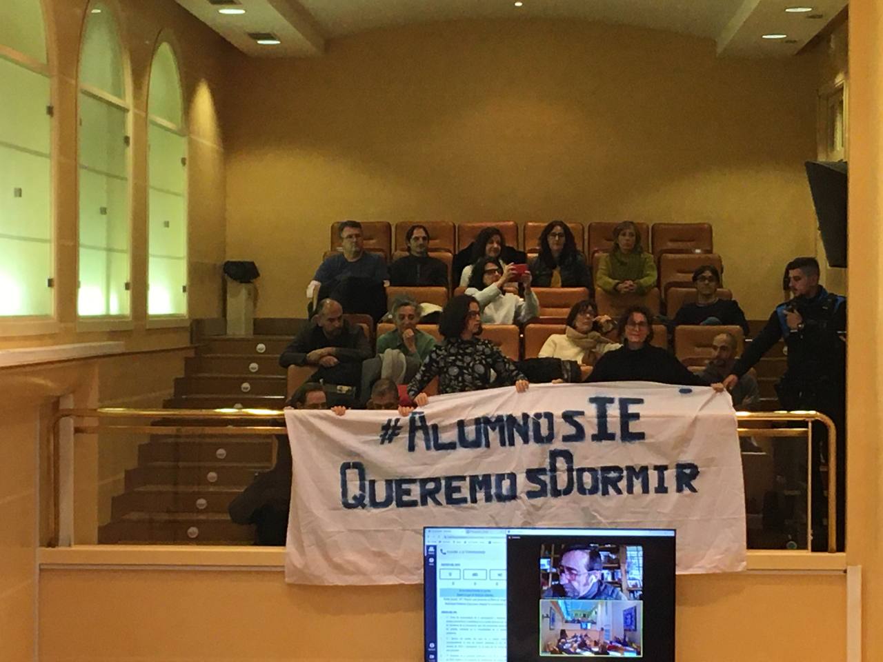 Varios vecinos del recinto amurallado desplegando una pancarta en la que se podía leer: “Alumnos IE queremos dormir”