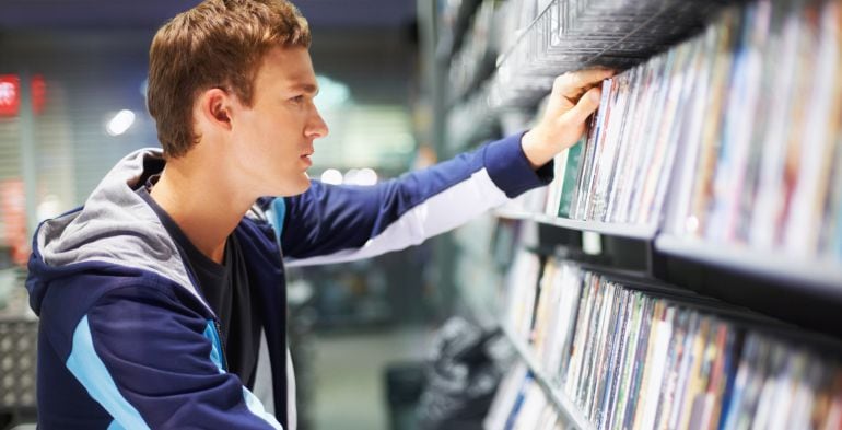 Un joven ante la variedad de películas de un videoclub.