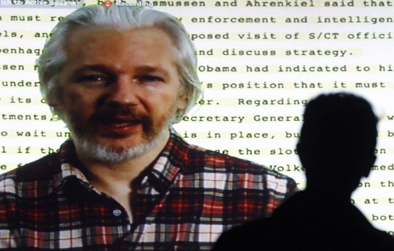 Founder of Wikileaks Julian Assange speaking from the Ecuadorean embassy in London appears on a screen as he gives a video conference to open the Human Rights Film Festival in Barcelona on October 22, 2014 following the screening of Mediastan, a film abou