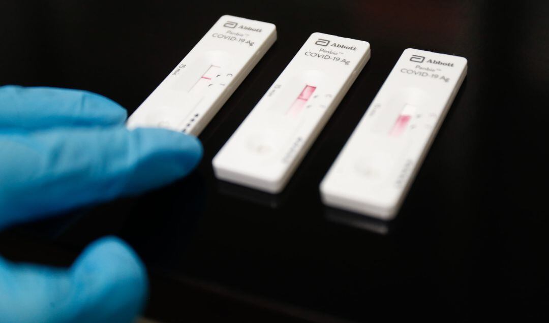 Una trabajadora sanitaria sostiene un test de antígenos.